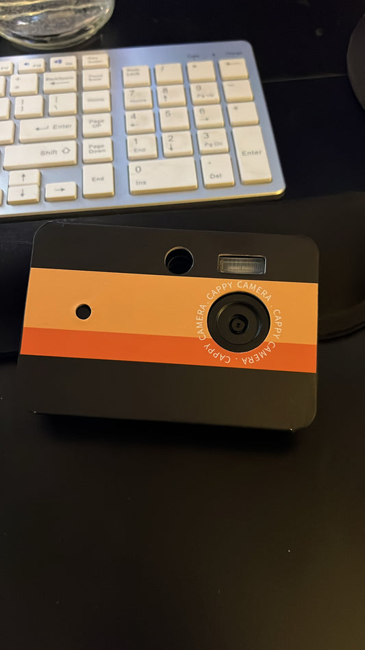 Cappy Camera on a desk in front of a computer keyboard